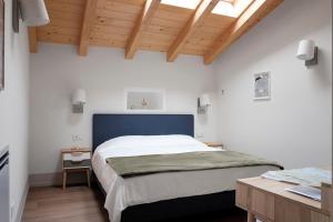 a bedroom with a large bed with a blue headboard at Passer Relais Bistrot in Menaggio