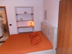 ドモドッソラにあるAppartamento Vecchia Domoの小さなベッドルーム(オレンジ色の毛布付きのベッド付)