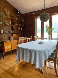a dining room with a white table and chairs at Cabin by Oppstrynsvatnet, Hjelle in Stryn