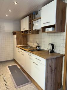 a kitchen with white cabinets and a wooden counter top at Zum Sterngässchen in Ludwigshafen am Rhein