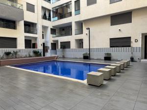 a swimming pool in front of a building at Studio Appartement MIRAMAR in Mohammedia