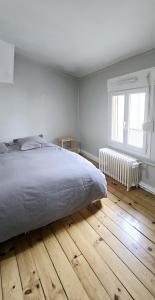 a bedroom with a bed and a wooden floor at Moulins F4 en centre ville Saint Dizier in Saint-Dizier