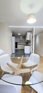 a room with white chairs and a glass table at Moulins F4 en centre ville Saint Dizier in Saint-Dizier