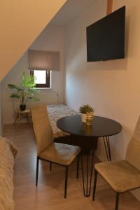 a living room with a table and chairs and a bed at Pino House in Zakopane