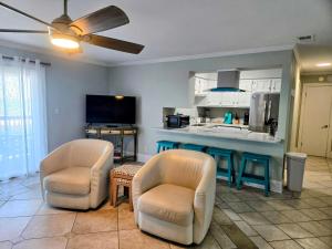 a living room with two chairs and a kitchen at Boardwalk #3 in Pensacola