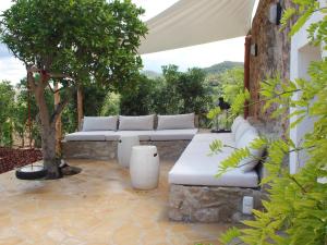a patio with white couches and a tree at New! Villa Finca Can Xo Ibiza in Sant Josep de Sa Talaia