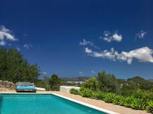 a swimming pool with a bench and a blue sky at New! Villa Finca Can Xo Ibiza in Sant Josep de Sa Talaia
