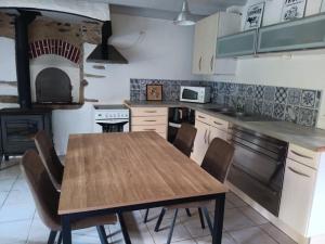 a kitchen with a wooden table and a stove at Gîte les 3 petits porcelets in Missillac +27 photos