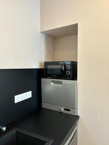 a kitchen with a microwave on top of a refrigerator at Studio centre ville La Bourboule in La Bourboule +4 photos