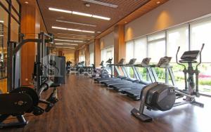 a gym with a row of treadmills and machines at Sky House BSD in Samporo