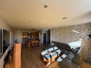a living room with a couch and a kitchen at Ferienhaus Maxe in Fehmarn