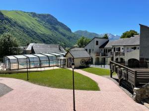a view of a house with a green hill in the background at Appartement avec balcon et vue sur les montagnes in Bielle