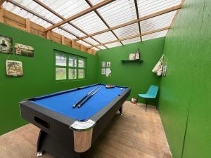 una mesa de billar en una habitación con paredes verdes en L,échappée Belle, en Dinard