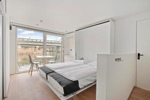 una camera da letto con un letto, un tavolo e delle sedie di HouseBoat the New Lake - Nieuwe Meer ad Amsterdam