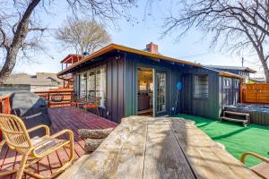 ein kleines grünes Haus mit einem Picknicktisch auf einer Terrasse in der Unterkunft Creekside Cottage with Deck and Hot Tub in Belton in Belton