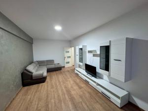 a living room with a couch and a flat screen tv at Apartament Valcea in Râmnicu Vâlcea