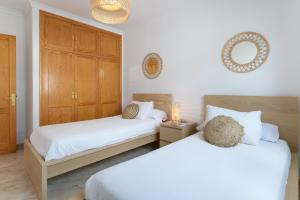a bedroom with two beds and a cabinet at VILLA ERIC with a private stunning heated pool in Puerto del Carmen +20 photos