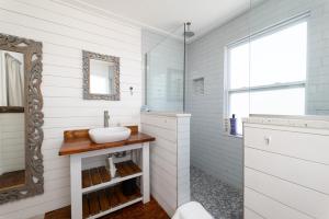 ein weißes Badezimmer mit Waschbecken und Spiegel in der Unterkunft Be a Nomad - Charming bch cottage - 3 blks to bch in Jacksonville Beach + 12 Fotos