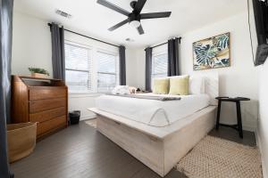 ein Schlafzimmer mit einem großen Bett und einem Deckenventilator in der Unterkunft Be a Nomad - Charming bch cottage - 3 blks to bch in Jacksonville Beach