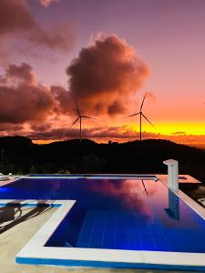 ein Schwimmbad mit Windturbinen im Hintergrund in der Unterkunft Margarida 03 in Monte das Gameleiras + 4 Fotos
