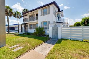 ein weißes Haus mit einem Zaun und Palmen in der Unterkunft Be a Nomad - Charming bch cottage - 3 blks to bch in Jacksonville Beach