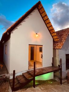 ein kleines weißes Haus mit einer Holzterrasse in der Unterkunft Margarida 03 in Monte das Gameleiras
