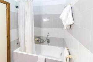 a bathroom with a bath tub with a shower curtain at Albergo Palazzo Terme & Wellness in Santa Cesarea Terme +62 photos