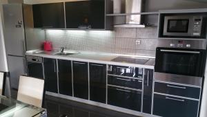 cocina con fregadero y microondas en Comfort Deluxe Kosmos Apartments, en Ohrid