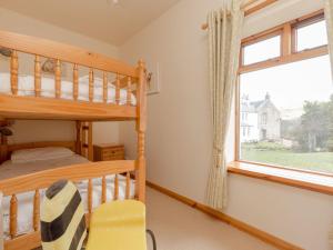 ein Schlafzimmer mit Etagenbett und Fenster in der Unterkunft Holiday Home Foxglove cottage by Interhome in Straiton