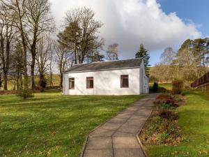 Ein weißes Haus auf einem Feld mit Bürgersteig in der Unterkunft Holiday Home Foxglove cottage by Interhome in Straiton