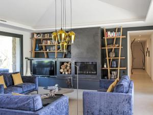 a living room with blue couches and a fireplace at Villa La Cupulatta by Interhome in Sainte-Lucie de Porto-Vecchio