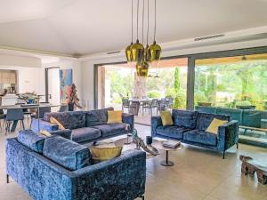 a living room with blue couches and a table at Villa La Cupulatta by Interhome in Sainte-Lucie de Porto-Vecchio