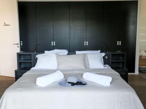 a large white bed with a hat and two pillows at Villa La Cupulatta by Interhome in Sainte-Lucie de Porto-Vecchio +21 photos