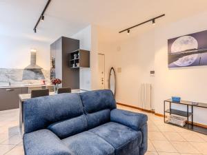 a living room with a blue couch and a kitchen at Apartment Jai Jai by Interhome in Colico