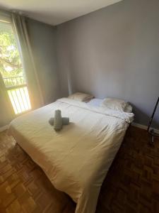 a bedroom with a bed with a teddy bear on it at Appartement Aéroport Orly 8 min, ligne 14 in Villejuif