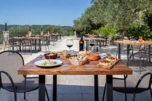 a wooden table with food and wine on a patio at Agriturismo Fara del Falco in Vieste