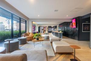 a lobby of a building with couches and tables at Housi Faria Lima in Sao Paulo