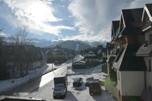 a city street with cars parked in the snow at Pino House in Zakopane