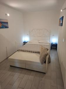 a white bed in a room with two lights at Il vigneto in Vernazza +3 photos