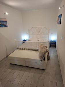 a white bed in a room with two lights at Il vigneto in Vernazza