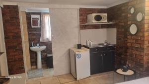 una piccola cucina con lavello e microonde di Eagles Rest a Klerksdorp