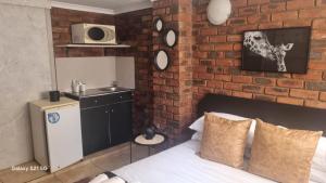 una camera da letto con un muro di mattoni, un letto e un forno a microonde di Eagles Rest a Klerksdorp