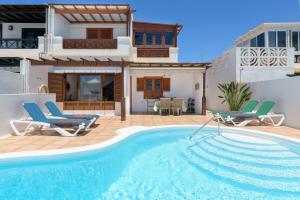 a villa with a swimming pool and a house at VILLA ERIC with a private stunning heated pool in Puerto del Carmen