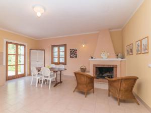 a living room with a fireplace and a table and chairs at Holiday Home Vignola House 2 by Interhome in Aglientu