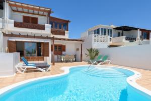 a villa with a swimming pool and a house at VILLA ERIC with a private stunning heated pool in Puerto del Carmen