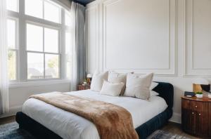 a bedroom with a large bed with two windows at The Purple Martin - The Perch in Louisville
