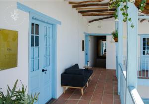 a hallway with a blue door and a chair at Hotel Casa Manoa Sesquile in Sesquilé