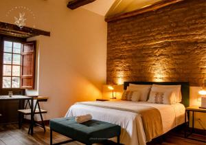a bedroom with a large bed and a stone wall at Hotel Casa Manoa Sesquile in Sesquilé +22 photos