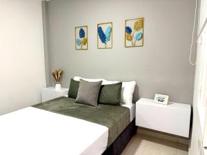 ein Schlafzimmer mit einem Bett und zwei weißen Tischen in der Unterkunft Elegance in the heart of wine in Lemos