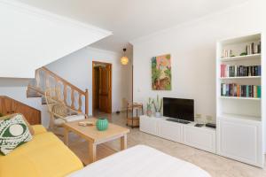 a living room with a couch and a tv at VILLA ERIC with a private stunning heated pool in Puerto del Carmen